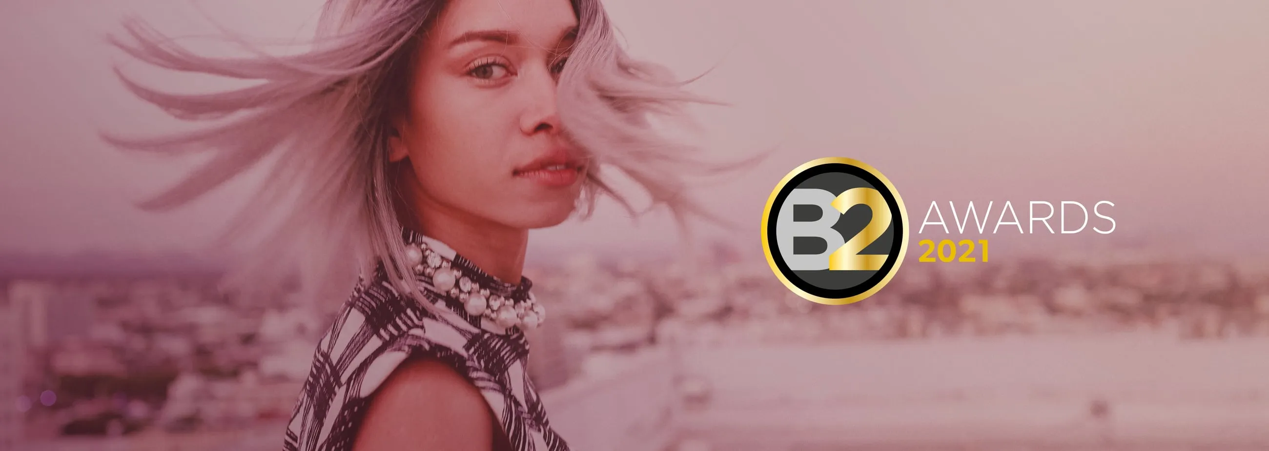Hero image for 'Catching Feels' campaign with a woman looking over her shoulder, with the gold and black B2 Awards logo on top.